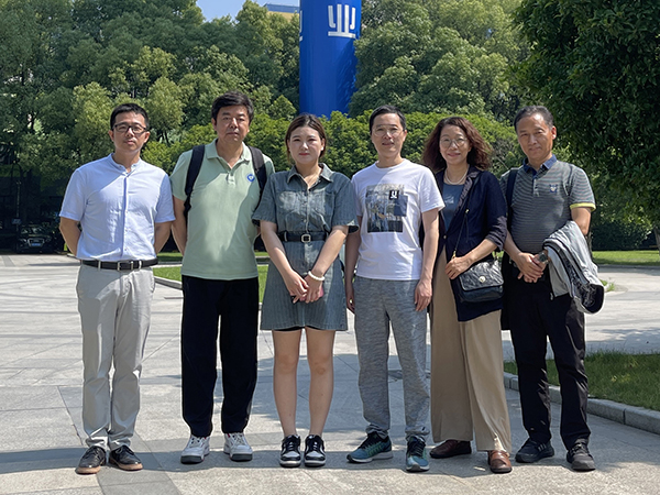 图为毕业生李梓萌（中）与老师们在走访现场合影